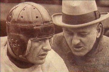Red Grange talking with a football coach