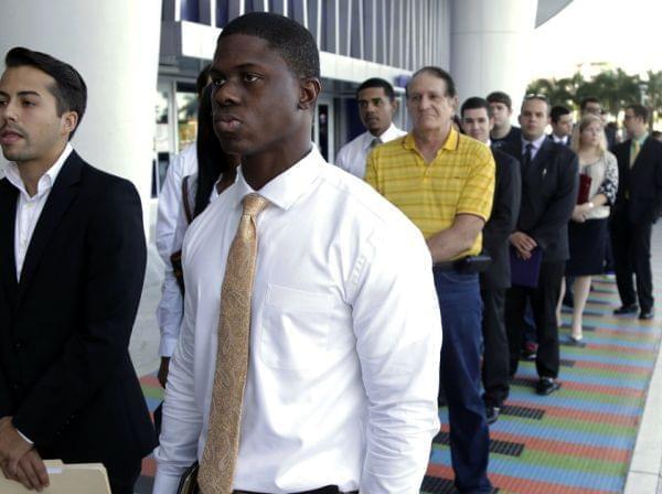 Luis Mendez, 23, left, and Maurice Mike, 23, wait in line at a job fair held by the Miami Marlins at Marlins Park in Miami on Oct. 23, 2013. The nation's unemployment rate slipped to 6.6 percent in January, but employers added only 113,000 jobs