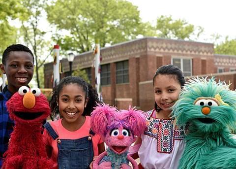 Kids smiling with Sesame Street characters